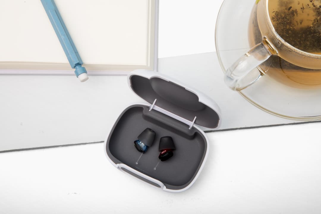 Mini hearing aids on charging case 