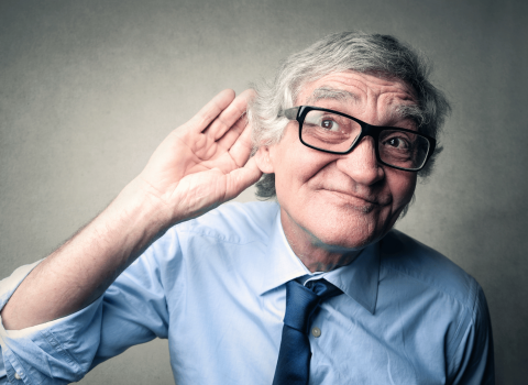 man holds hand to ear to try to understand speech and words